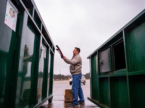 Photograph of person recycling cardboard